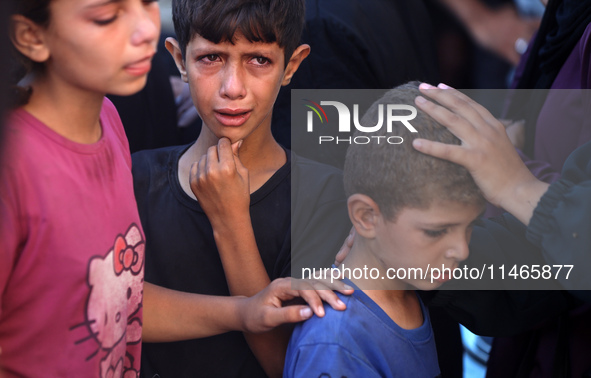 Palestinians are mourning by the bodies of relatives killed in Israeli bombardment on Nuseirat in the central Gaza Strip at Al-Aqsa Martyrs...