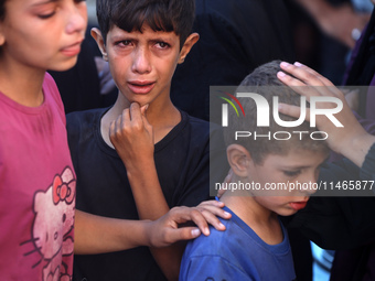 Palestinians are mourning by the bodies of relatives killed in Israeli bombardment on Nuseirat in the central Gaza Strip at Al-Aqsa Martyrs...