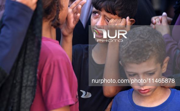 Palestinians are mourning by the bodies of relatives killed in Israeli bombardment on Nuseirat in the central Gaza Strip at Al-Aqsa Martyrs...