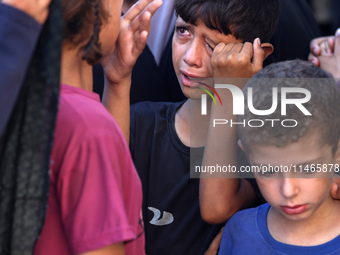 Palestinians are mourning by the bodies of relatives killed in Israeli bombardment on Nuseirat in the central Gaza Strip at Al-Aqsa Martyrs...