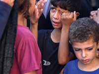 Palestinians are mourning by the bodies of relatives killed in Israeli bombardment on Nuseirat in the central Gaza Strip at Al-Aqsa Martyrs...