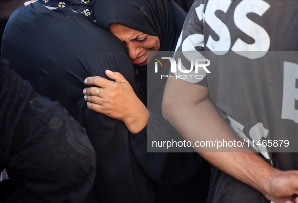 Palestinians are mourning by the bodies of relatives killed in Israeli bombardment on Nuseirat in the central Gaza Strip at Al-Aqsa Martyrs...