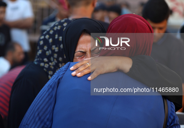 Palestinians are mourning by the bodies of relatives killed in Israeli bombardment on Nuseirat in the central Gaza Strip at Al-Aqsa Martyrs...