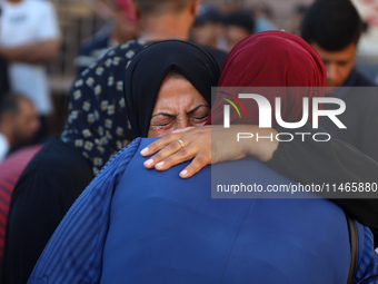 Palestinians are mourning by the bodies of relatives killed in Israeli bombardment on Nuseirat in the central Gaza Strip at Al-Aqsa Martyrs...