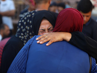 Palestinians are mourning by the bodies of relatives killed in Israeli bombardment on Nuseirat in the central Gaza Strip at Al-Aqsa Martyrs...