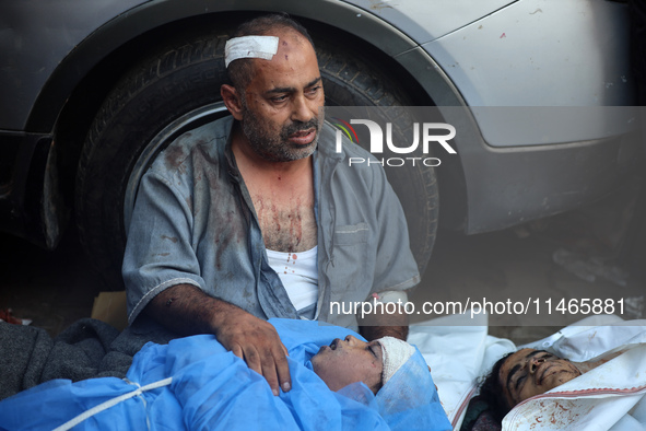 Palestinians are mourning by the bodies of relatives killed in Israeli bombardment on Nuseirat in the central Gaza Strip at Al-Aqsa Martyrs...