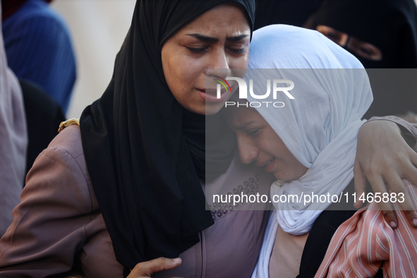 Palestinians are mourning by the bodies of relatives killed in Israeli bombardment on Nuseirat in the central Gaza Strip at Al-Aqsa Martyrs...