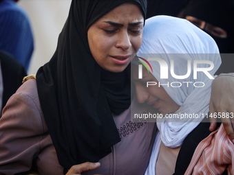 Palestinians are mourning by the bodies of relatives killed in Israeli bombardment on Nuseirat in the central Gaza Strip at Al-Aqsa Martyrs...