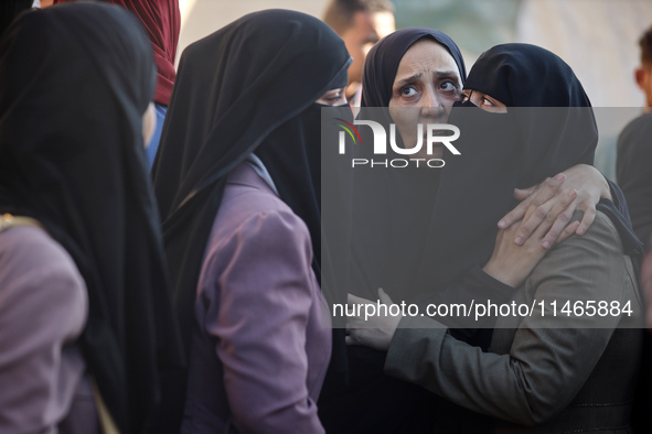 Palestinians are mourning by the bodies of relatives killed in Israeli bombardment on Nuseirat in the central Gaza Strip at Al-Aqsa Martyrs...