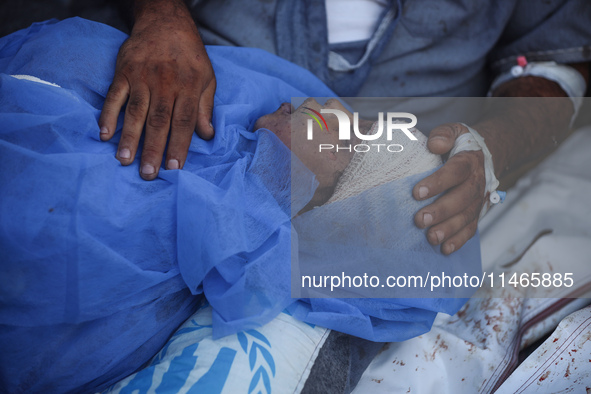 Palestinians are mourning by the bodies of relatives killed in Israeli bombardment on Nuseirat in the central Gaza Strip at Al-Aqsa Martyrs...