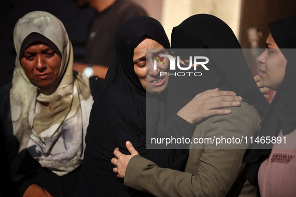 Palestinians are mourning by the bodies of relatives killed in Israeli bombardment on Nuseirat in the central Gaza Strip at Al-Aqsa Martyrs...