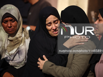 Palestinians are mourning by the bodies of relatives killed in Israeli bombardment on Nuseirat in the central Gaza Strip at Al-Aqsa Martyrs...