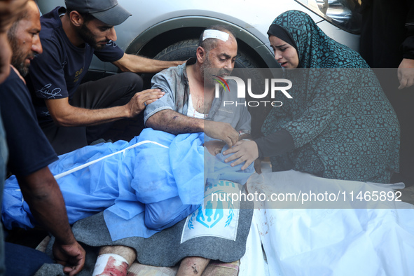 Palestinians are mourning by the bodies of relatives killed in Israeli bombardment on Nuseirat in the central Gaza Strip at Al-Aqsa Martyrs...