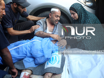 Palestinians are mourning by the bodies of relatives killed in Israeli bombardment on Nuseirat in the central Gaza Strip at Al-Aqsa Martyrs...