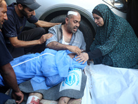 Palestinians are mourning by the bodies of relatives killed in Israeli bombardment on Nuseirat in the central Gaza Strip at Al-Aqsa Martyrs...