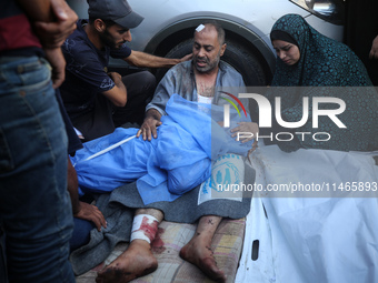 Palestinians are mourning by the bodies of relatives killed in Israeli bombardment on Nuseirat in the central Gaza Strip at Al-Aqsa Martyrs...