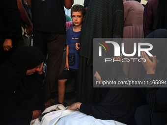 Palestinians are mourning by the bodies of relatives killed in Israeli bombardment on Nuseirat in the central Gaza Strip at Al-Aqsa Martyrs...