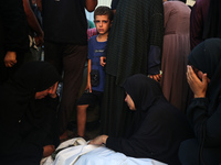 Palestinians are mourning by the bodies of relatives killed in Israeli bombardment on Nuseirat in the central Gaza Strip at Al-Aqsa Martyrs...