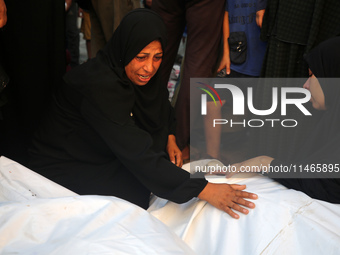 Palestinians are mourning by the bodies of relatives killed in Israeli bombardment on Nuseirat in the central Gaza Strip at Al-Aqsa Martyrs...