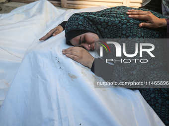 Palestinians are mourning by the bodies of relatives killed in Israeli bombardment on Nuseirat in the central Gaza Strip at Al-Aqsa Martyrs...