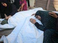 Palestinians are mourning by the bodies of relatives killed in Israeli bombardment on Nuseirat in the central Gaza Strip at Al-Aqsa Martyrs...