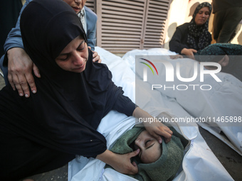 Palestinians are mourning by the bodies of relatives killed in Israeli bombardment on Nuseirat in the central Gaza Strip at Al-Aqsa Martyrs...