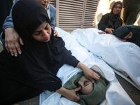 Palestinians are mourning by the bodies of relatives killed in Israeli bombardment on Nuseirat in the central Gaza Strip at Al-Aqsa Martyrs...