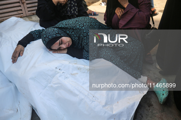 Palestinians are mourning by the bodies of relatives killed in Israeli bombardment on Nuseirat in the central Gaza Strip at Al-Aqsa Martyrs...