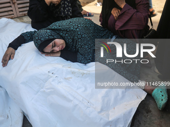 Palestinians are mourning by the bodies of relatives killed in Israeli bombardment on Nuseirat in the central Gaza Strip at Al-Aqsa Martyrs...