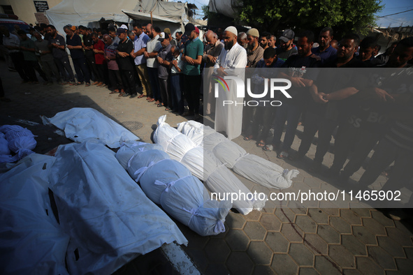 People are praying near the bodies of Palestinians killed in Israeli strikes, amid the Israel-Hamas conflict, at Al-Aqsa Martyrs Hospital in...