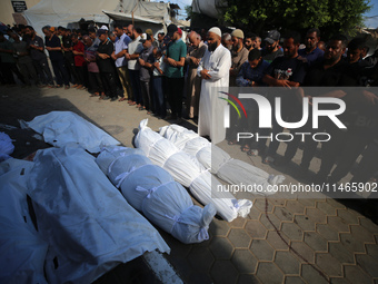 People are praying near the bodies of Palestinians killed in Israeli strikes, amid the Israel-Hamas conflict, at Al-Aqsa Martyrs Hospital in...