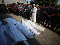 People are praying near the bodies of Palestinians killed in Israeli strikes, amid the Israel-Hamas conflict, at Al-Aqsa Martyrs Hospital in...