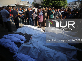 People are praying near the bodies of Palestinians killed in Israeli strikes, amid the Israel-Hamas conflict, at Al-Aqsa Martyrs Hospital in...