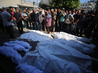 People are praying near the bodies of Palestinians killed in Israeli strikes, amid the Israel-Hamas conflict, at Al-Aqsa Martyrs Hospital in...