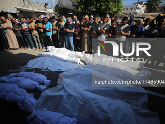 People are praying near the bodies of Palestinians killed in Israeli strikes, amid the Israel-Hamas conflict, at Al-Aqsa Martyrs Hospital in...