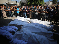 People are praying near the bodies of Palestinians killed in Israeli strikes, amid the Israel-Hamas conflict, at Al-Aqsa Martyrs Hospital in...