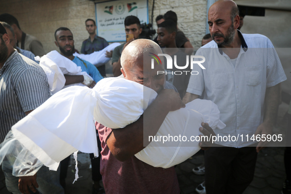 Palestinians are mourning by the bodies of relatives killed in Israeli bombardment on Nuseirat in the central Gaza Strip at Al-Aqsa Martyrs...