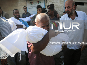 Palestinians are mourning by the bodies of relatives killed in Israeli bombardment on Nuseirat in the central Gaza Strip at Al-Aqsa Martyrs...