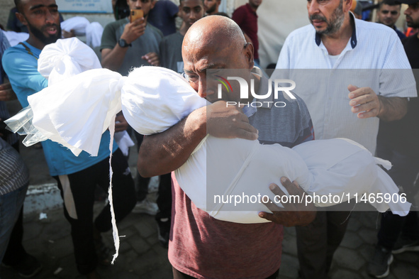 Palestinians are mourning by the bodies of relatives killed in Israeli bombardment on Nuseirat in the central Gaza Strip at Al-Aqsa Martyrs...