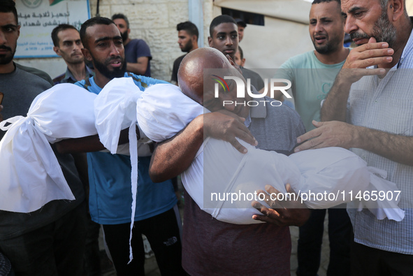 Palestinians are mourning by the bodies of relatives killed in Israeli bombardment on Nuseirat in the central Gaza Strip at Al-Aqsa Martyrs...