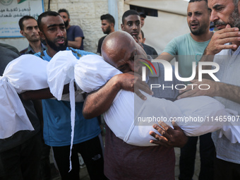 Palestinians are mourning by the bodies of relatives killed in Israeli bombardment on Nuseirat in the central Gaza Strip at Al-Aqsa Martyrs...