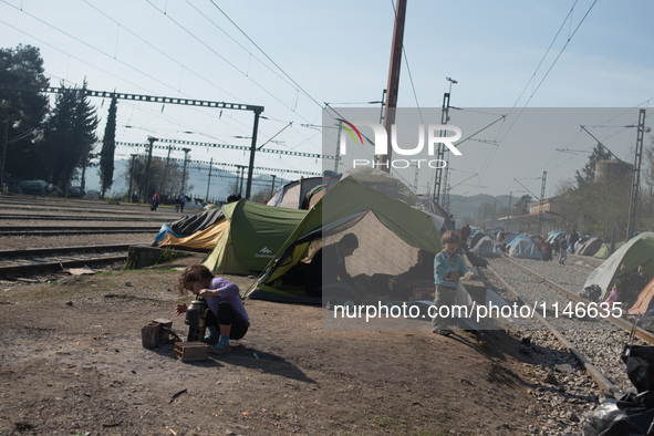 Girl prepares Shai will her fathers wake up in Idomeni Camp on April 6, 2016.. A plan to send back migrants from Greece to Turkey sparked de...