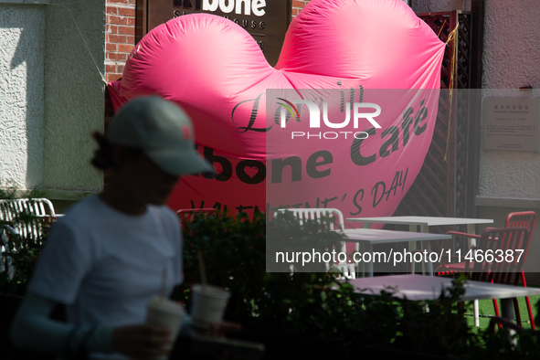 A large heart balloon is being placed at an outdoor cafe during Qixi, a Chinese traditional Valentine, in Shanghai, China, on August 10, 202...