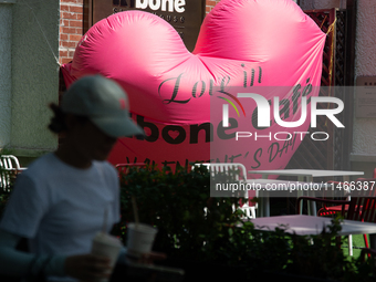 A large heart balloon is being placed at an outdoor cafe during Qixi, a Chinese traditional Valentine, in Shanghai, China, on August 10, 202...