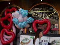 Large heart balloons are being placed at an outdoor cafe during Qixi, a Chinese traditional Valentine, in Shanghai, China, on August 10, 202...