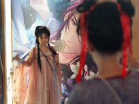 A woman in traditional Chinese Han dress is taking pictures at Yu Garden during Qixi, a traditional Chinese Valentine's Day, in Shanghai, Ch...