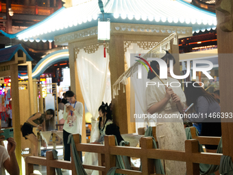 A woman is taking pictures in traditional Chinese Han dressing at Yu Garden during Qixi, a Chinese traditional Valentine, in Shanghai, China...