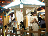 A woman is taking pictures in traditional Chinese Han dressing at Yu Garden during Qixi, a Chinese traditional Valentine, in Shanghai, China...