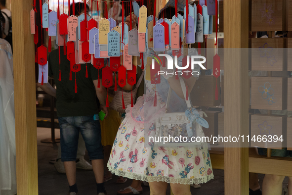 A woman is placing her wish at Yu Garden during Qixi, a Chinese traditional Valentine, in Shanghai, China, on August 10, 2024. 