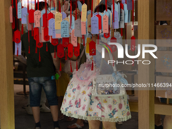 A woman is placing her wish at Yu Garden during Qixi, a Chinese traditional Valentine, in Shanghai, China, on August 10, 2024. (